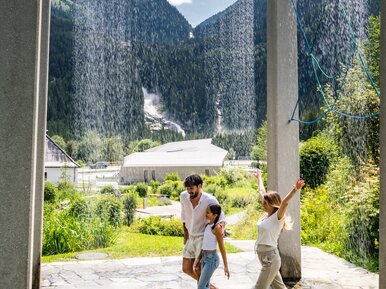 Krimmler WasserWelten, Familie unter Wasserfall-Vorhang | © wasserwelten.at/Michael Stabentheiner